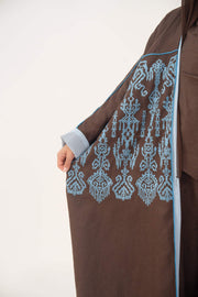 Mocha brown lightweight linen bisht abaya with blue shak embroidery and light blue piping on sleeves and shoulders.