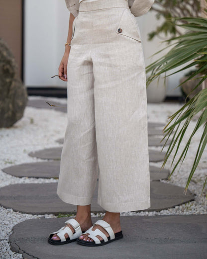 Beige Modern Pant with high waist and button details, cropped length styled with white sandals.