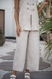 Beige Modern Pant with a structured waistband and button details, styled with white sandals.
