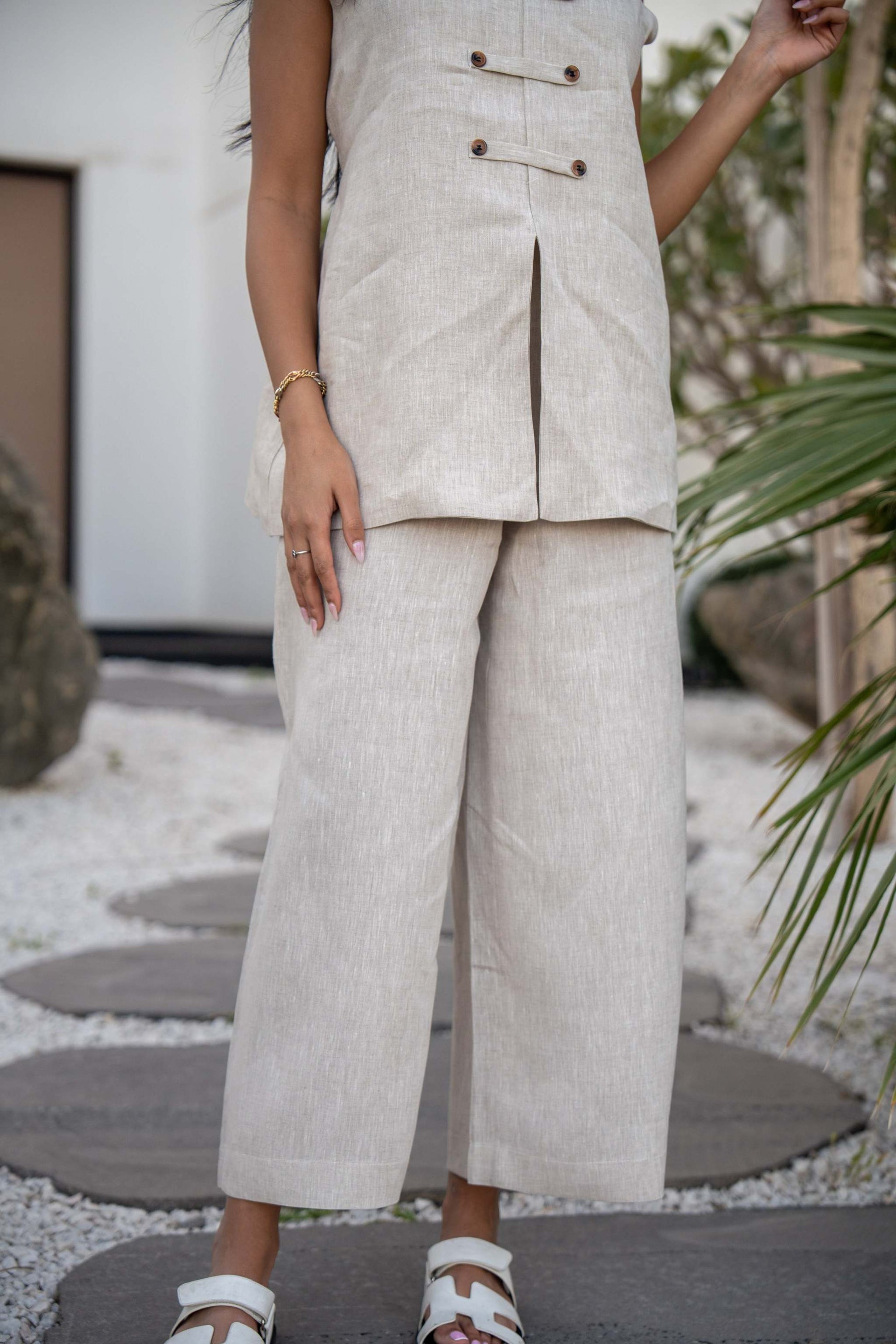 Beige Modern Pant with a structured waistband and button details, styled with white sandals.