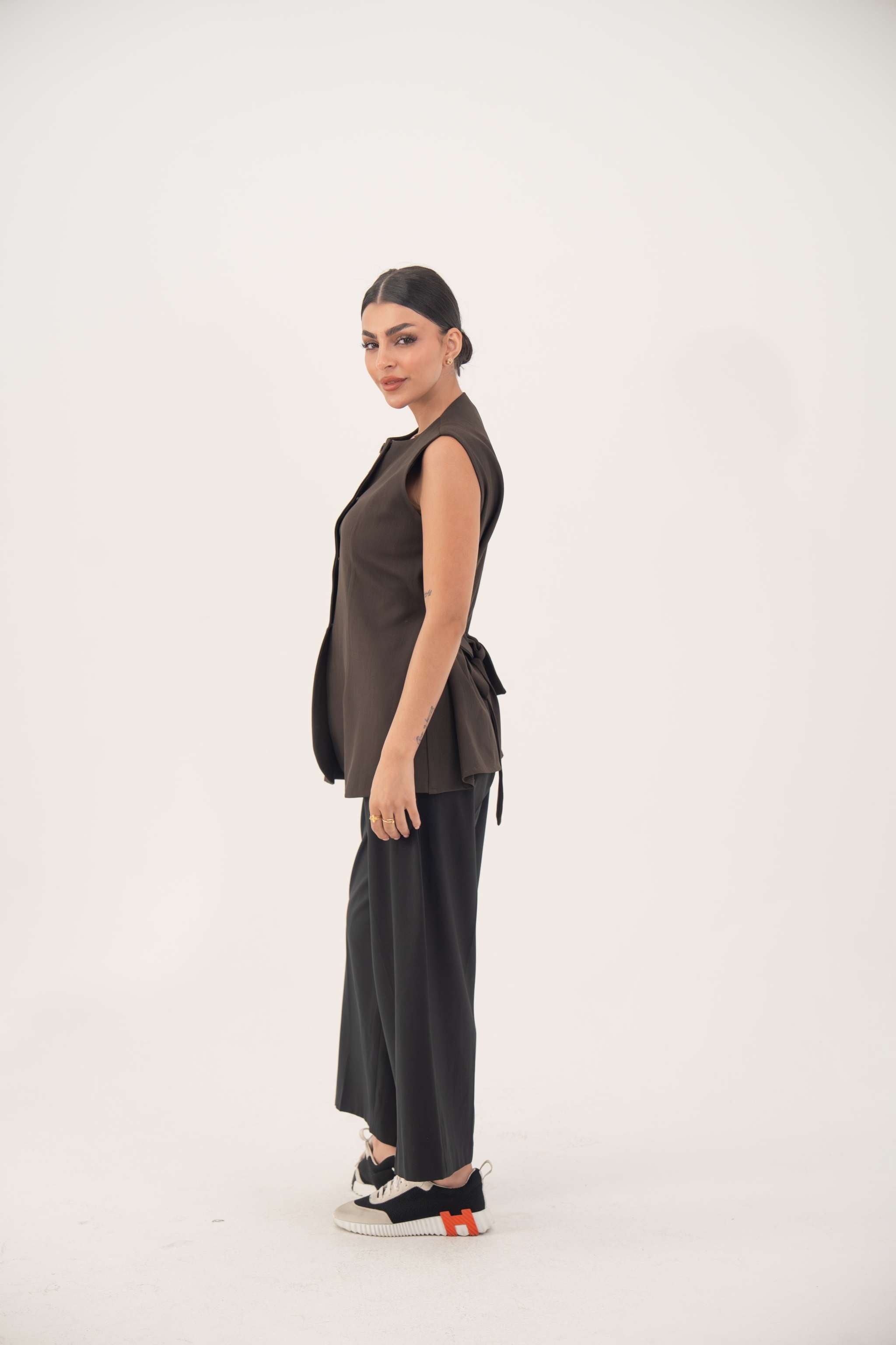 brown sleeveless crepe vest with nine front buttons and tailored fit