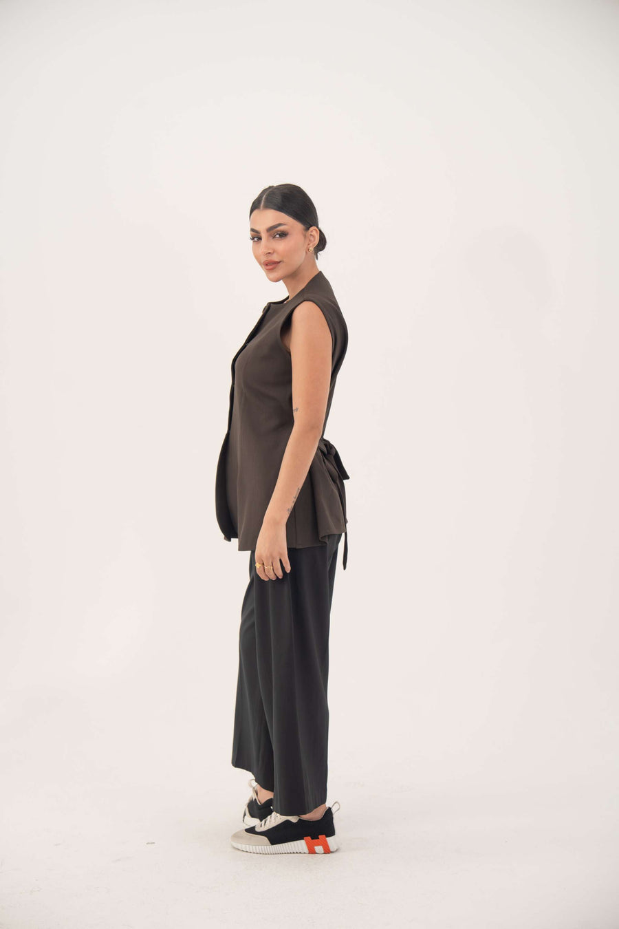brown sleeveless crepe vest with nine front buttons and tailored fit