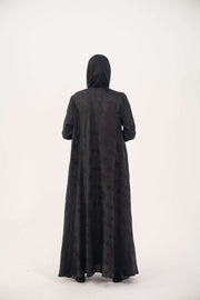 Back view of a black jacquard silk abaya with tone-on-tone floral weave, featuring a fluid A-line cut, relaxed shoulders, open front, straight sleeves, and discreet side pockets.