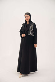 Black blazer abaya with crepe body and satin vest layer, featuring a notched collar and structured shoulders for a modern, elegant look.