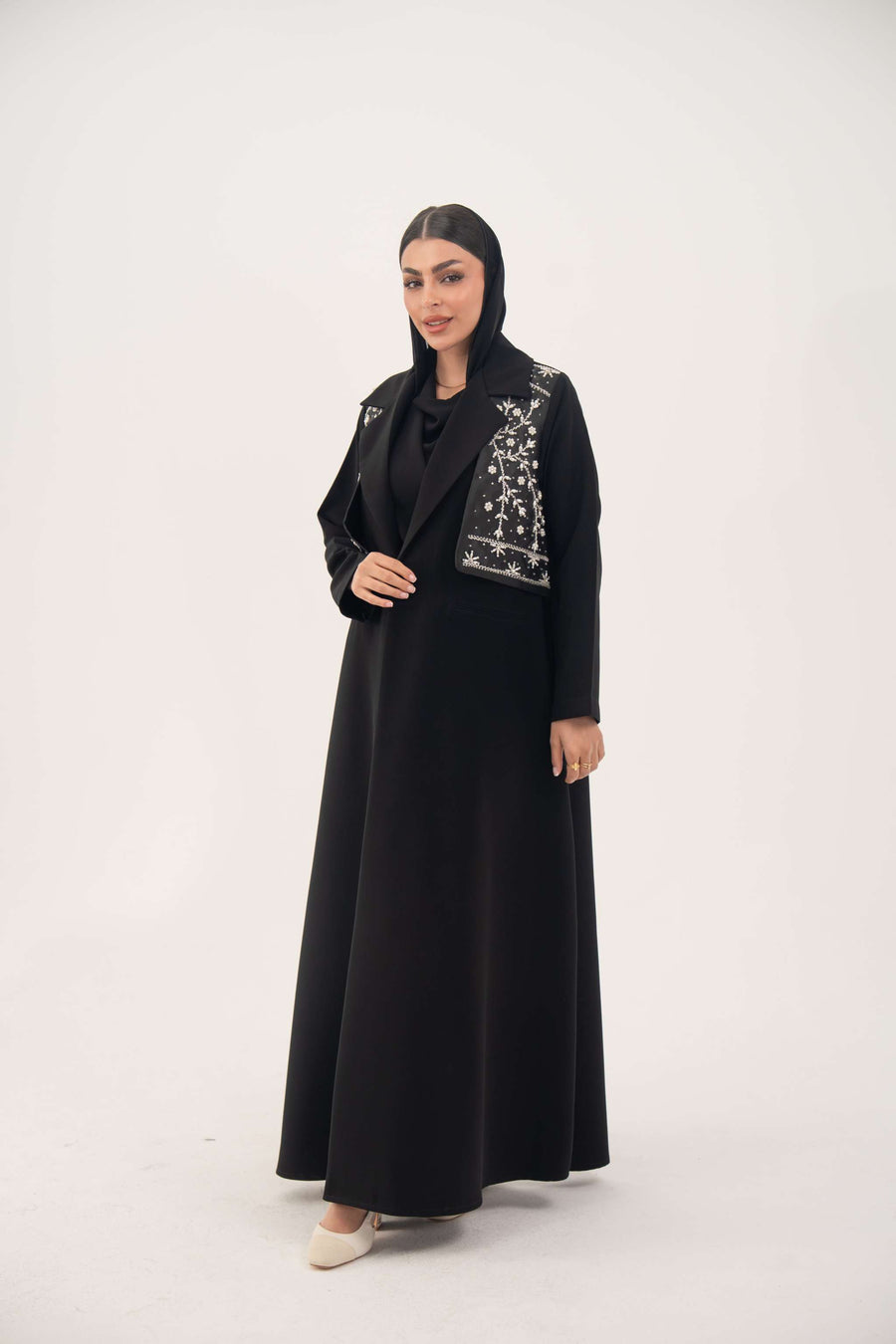 Black blazer abaya with crepe body and satin vest layer, featuring a notched collar and structured shoulders for a modern, elegant look.