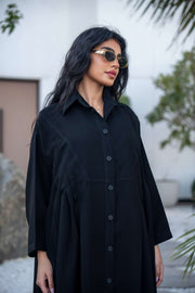 Woman wearing a classic black crepe abaya with a flowing silhouette and button-down front outdoors - Hannah