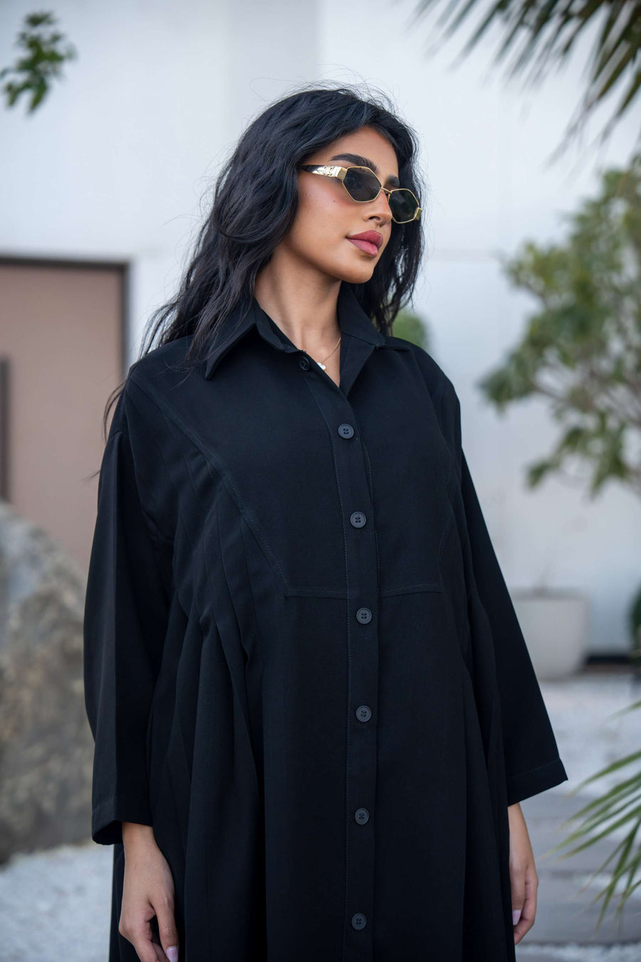 Woman wearing a classic black crepe abaya with a flowing silhouette and button-down front outdoors - Hannah