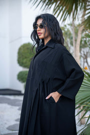 Woman wearing a classic black crepe abaya with a flowing silhouette and button-down front outdoors - Hannah