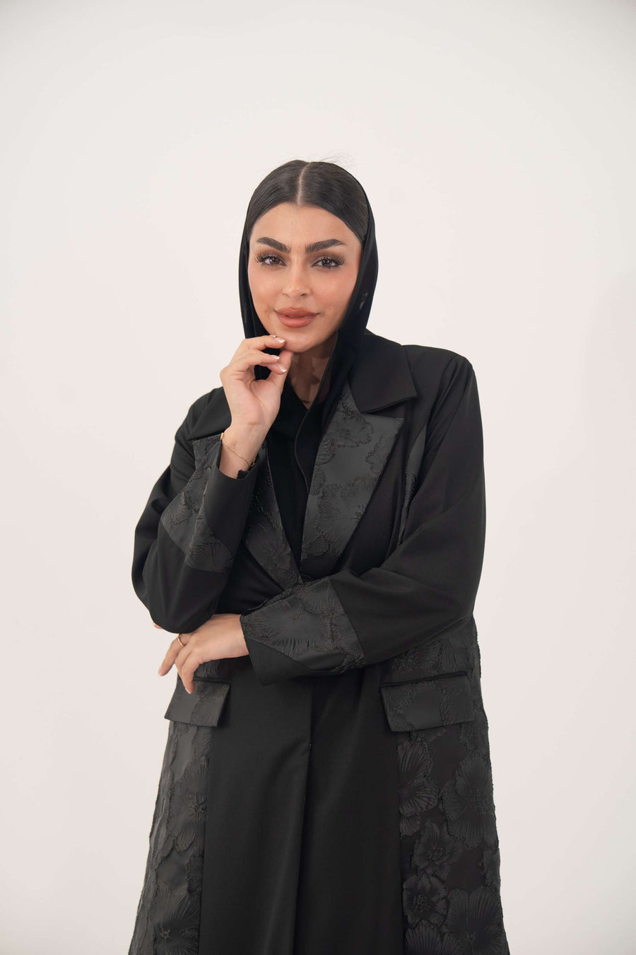 Woman wearing black jacquard blazer abaya with classic lapels and textured pattern