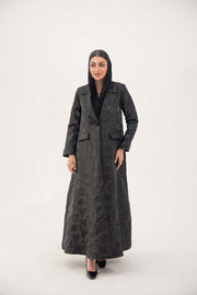 woman wearing a black jacquard blazer abaya with textured pattern and classic lapels