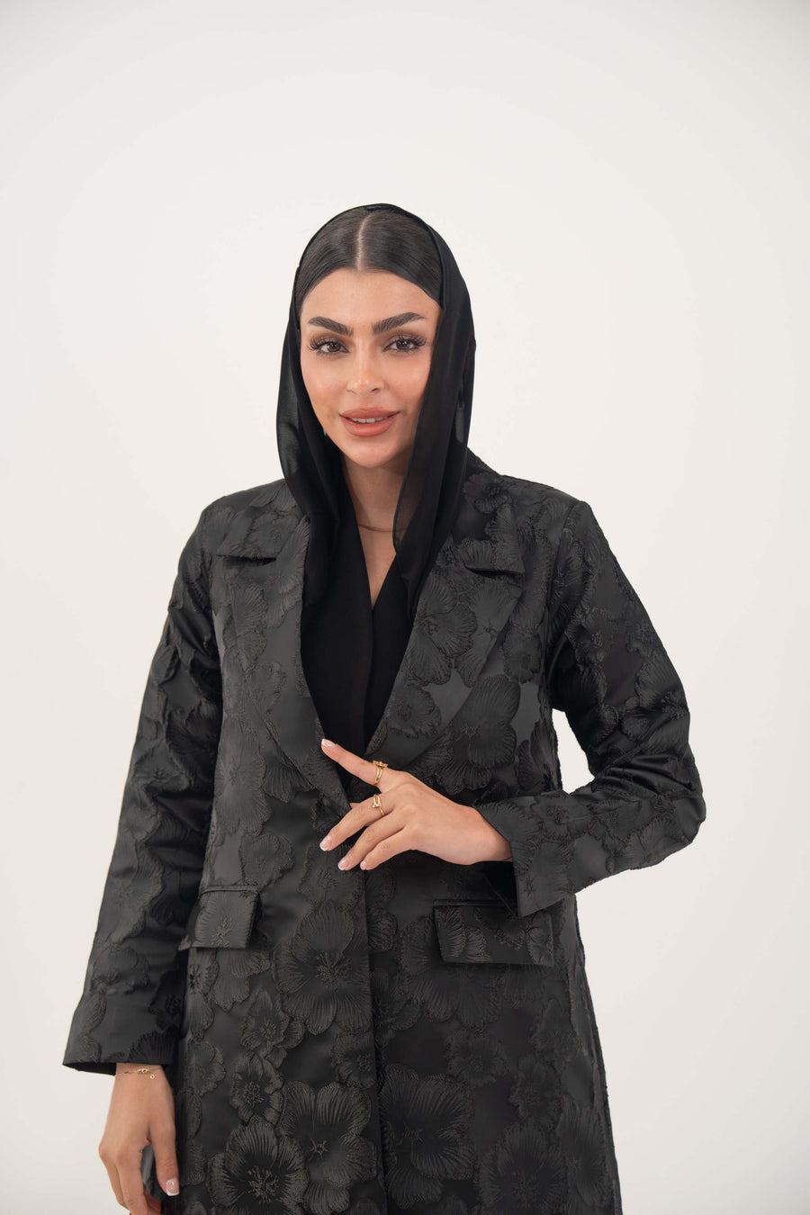 woman wearing black jacquard blazer abaya with textured pattern and classic lapels