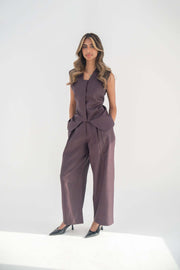 Woman wearing relaxed fit Ube Pant in deep purplish-brown twill linen blend paired with sleeveless top and black heels