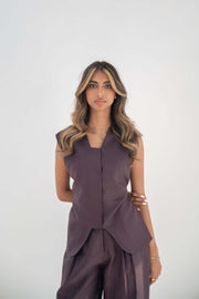 Woman wearing sleeveless ube vest made of high-quality twill linen blend with structured cut and hidden front buttons