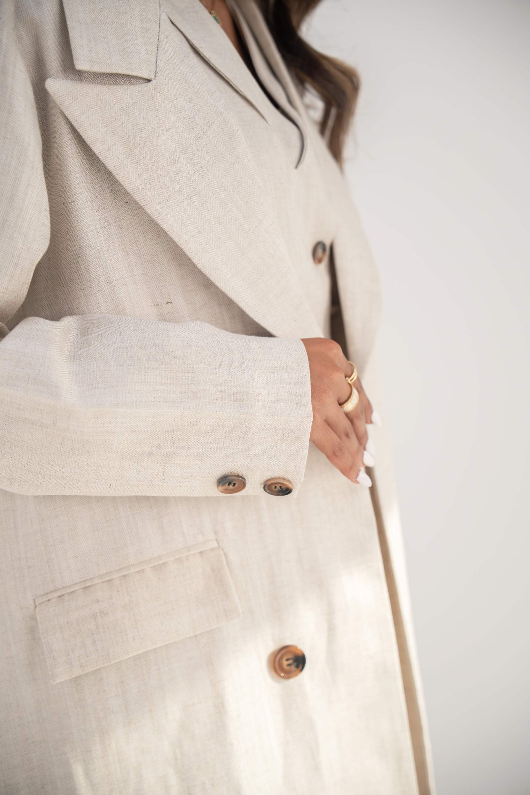 close-up of beige twill linen blend blazer-style abaya with notched lapel and front buttons