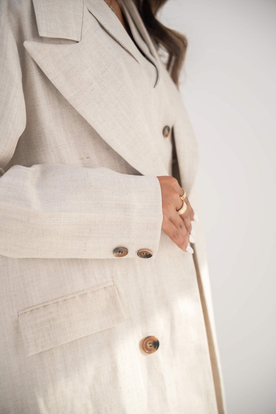 close-up of beige twill linen blend blazer-style abaya with notched lapel and front buttons
