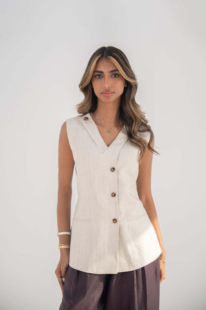 Beige sleeveless twill linen blend vest with V-neck, front buttons, side slits, and removable collar flap.
