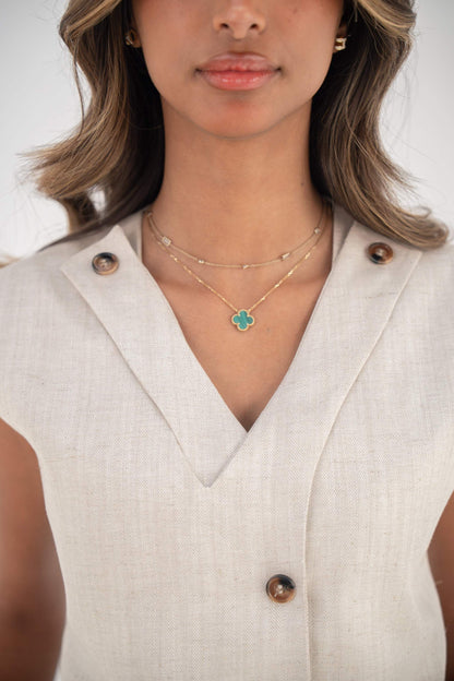 Close-up of a woman wearing a sleeveless beige Madeleine Vest with a V-neckline and front buttons made from twill linen blend.