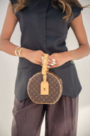 Navy twill linen blend blouse with hidden front buttons and structured cut, styled with brown pants and round designer handbag.
