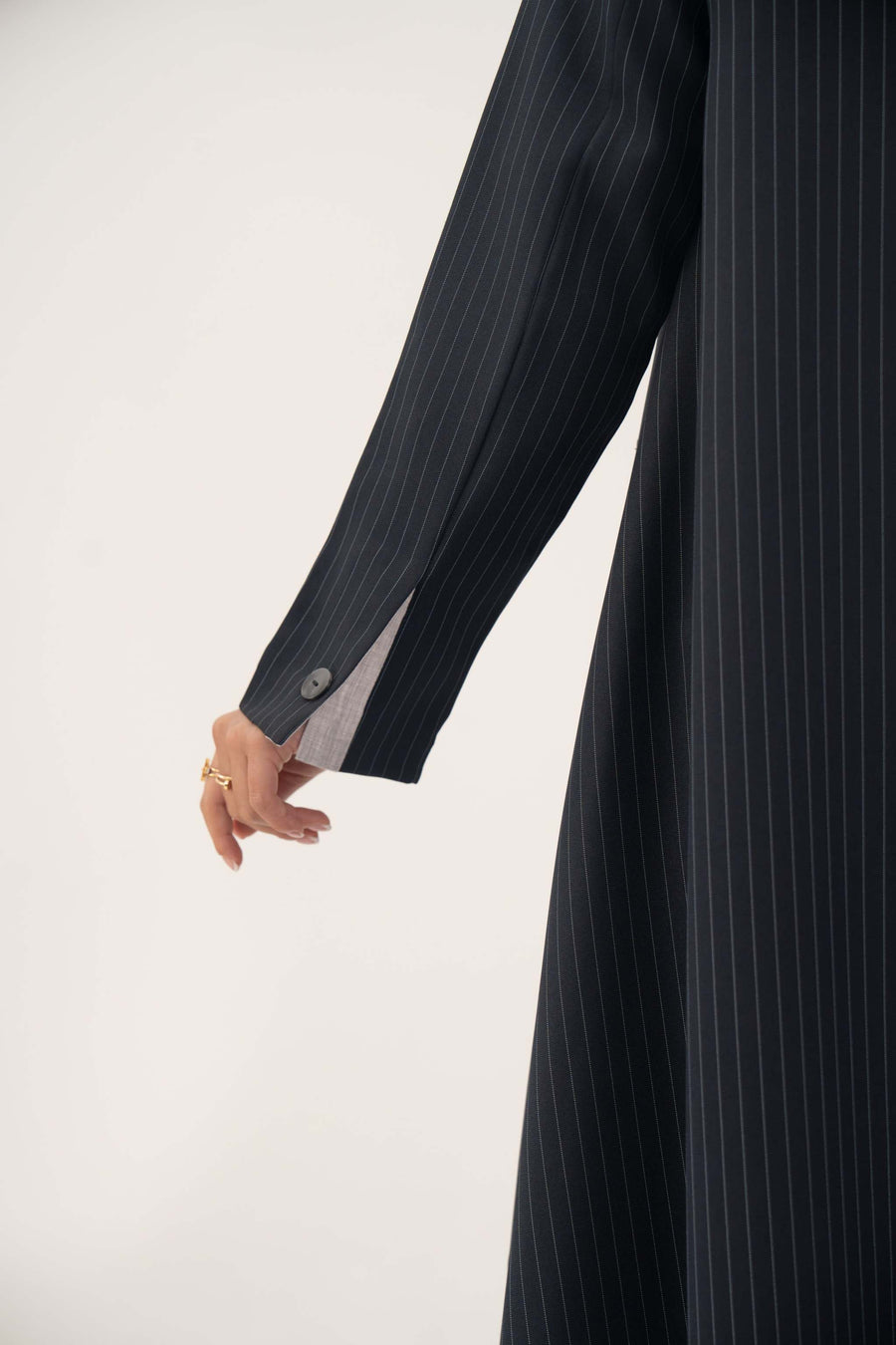 Close-up of a deep navy crepe blend blazer sleeve with fine white pinstripes and buttoned cuff from Zanira collection