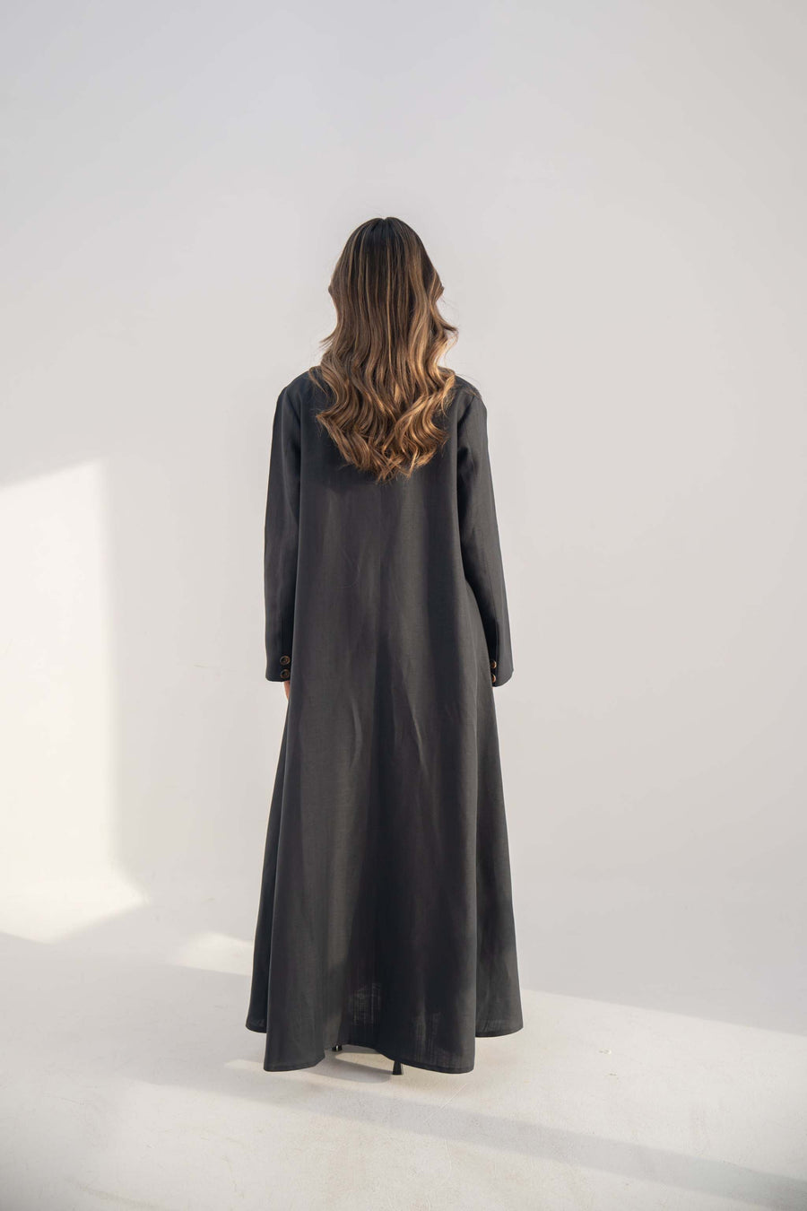 Navy blue blazer abaya in twill linen blend with long clean cut and button details shown from back.