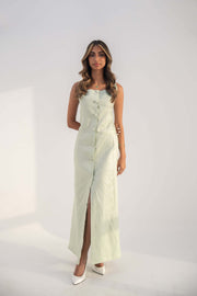 Woman wearing a sleeveless mint green Peppermint Inner dress with front buttons and a front slit