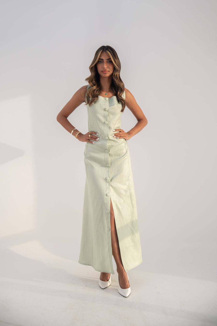 Woman wearing sleeveless mint green twill linen blend Peppermint Inner dress with front buttons and straight cut