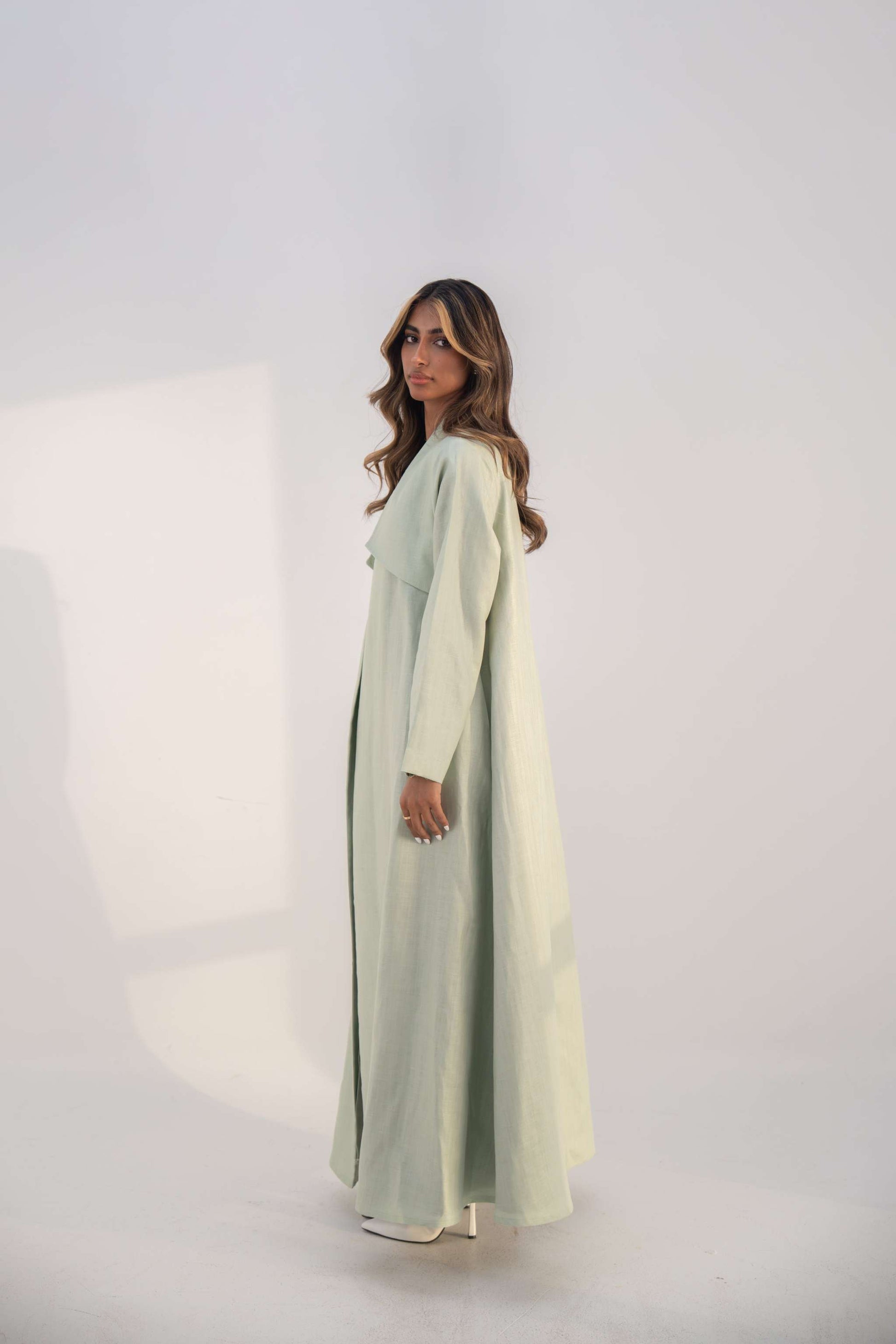 Mint green abaya crafted from soft twill linen blend with open front and draped collar for elegant layering