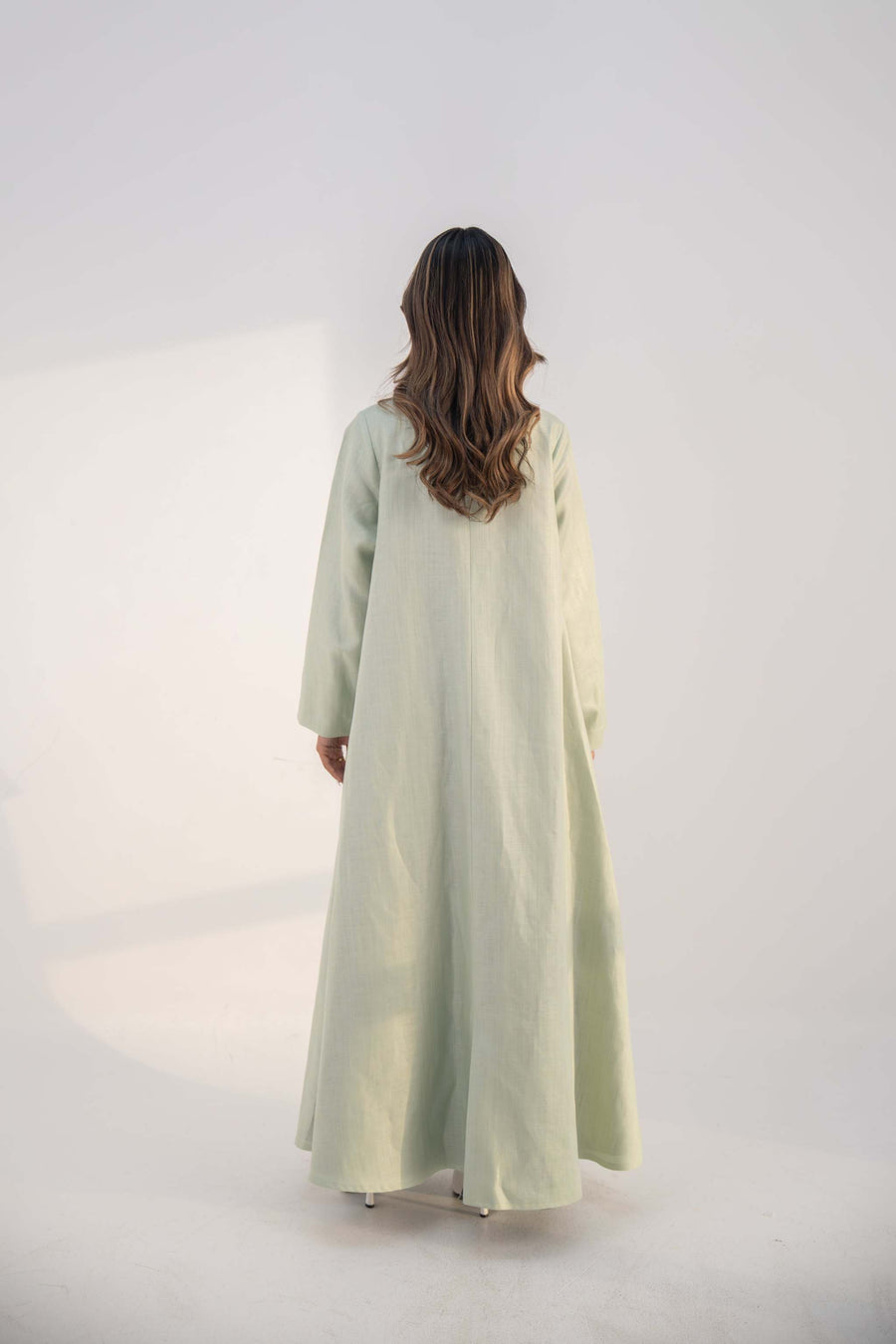 abaya crafted from soft twill linen blend in mint green with long, structured open-front design and draped collar