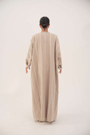 Back view of a creamy beige airy linen abaya with subtle tonal embroidery and soft chiffon cuffs, featuring a classic bisht silhouette and open front for graceful flow.