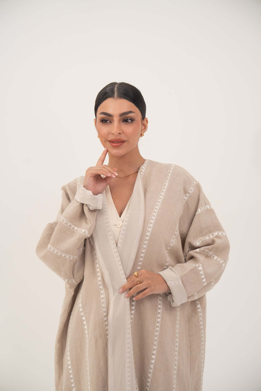 Elegant beige linen abaya with subtle tonal embroidery and soft chiffon cuffs for a light, breathable, and graceful fit
