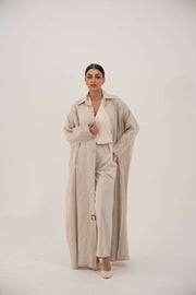 Sandora soft beige linen abaya with classic shirt collar and fabric-covered buttons.