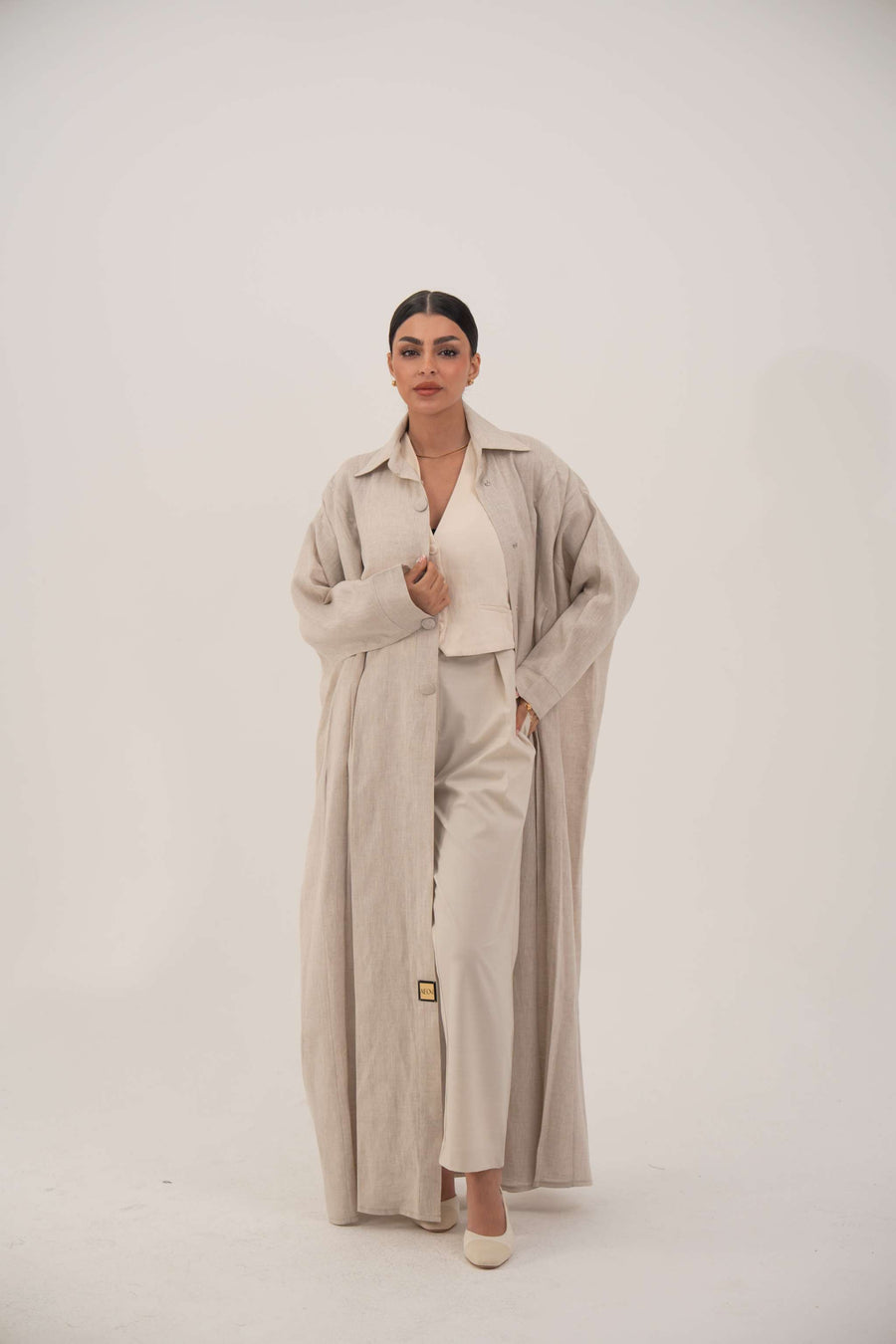 Sandora soft beige linen abaya with classic shirt collar and fabric-covered buttons.