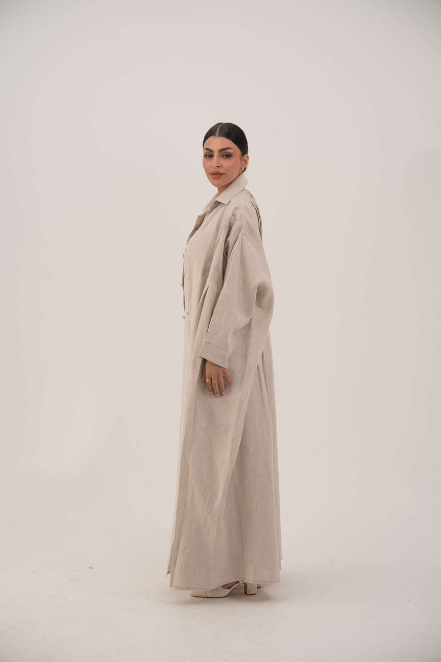 Sandora soft beige linen abaya with classic shirt collar and fabric-covered buttons.