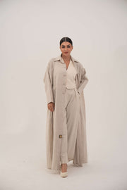 Sandora soft beige linen abaya with classic shirt collar and fabric-covered buttons.
