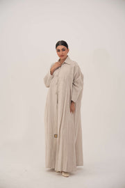 Sandora soft beige linen abaya with classic shirt collar and fabric-covered buttons.