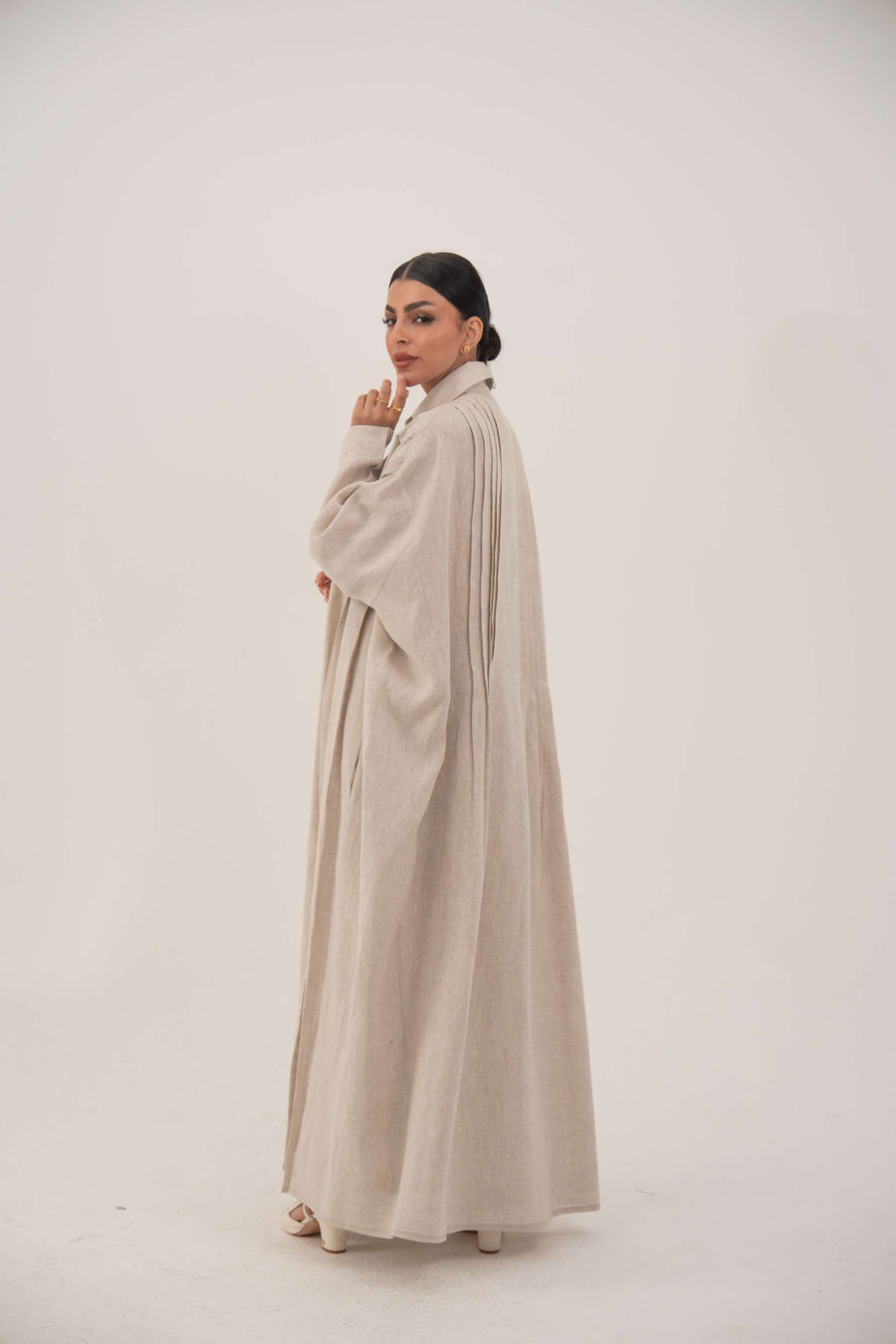 Sandora soft beige linen abaya with classic shirt collar and fabric-covered buttons.