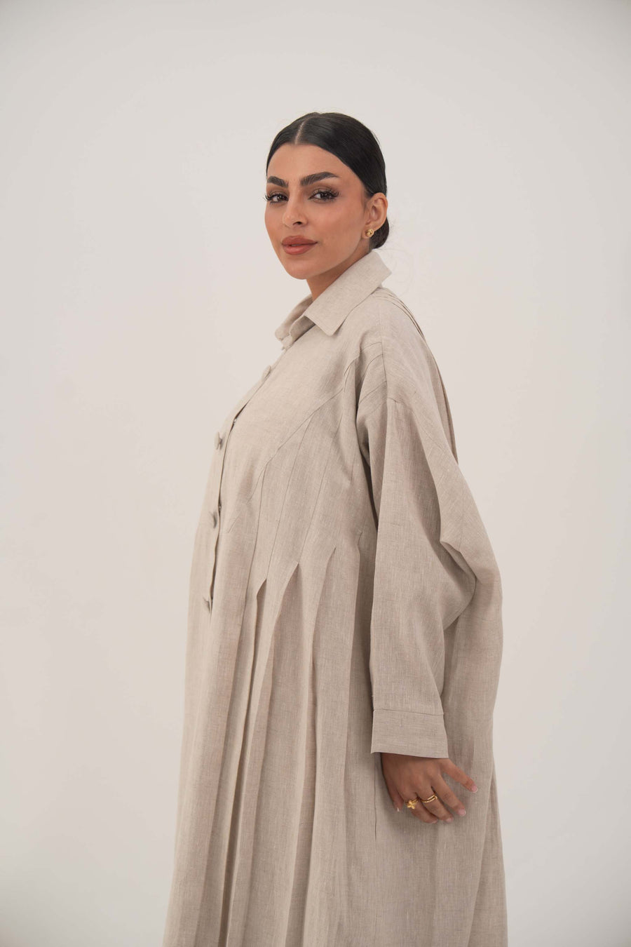 Sandora soft beige linen abaya with classic shirt collar and fabric-covered buttons.