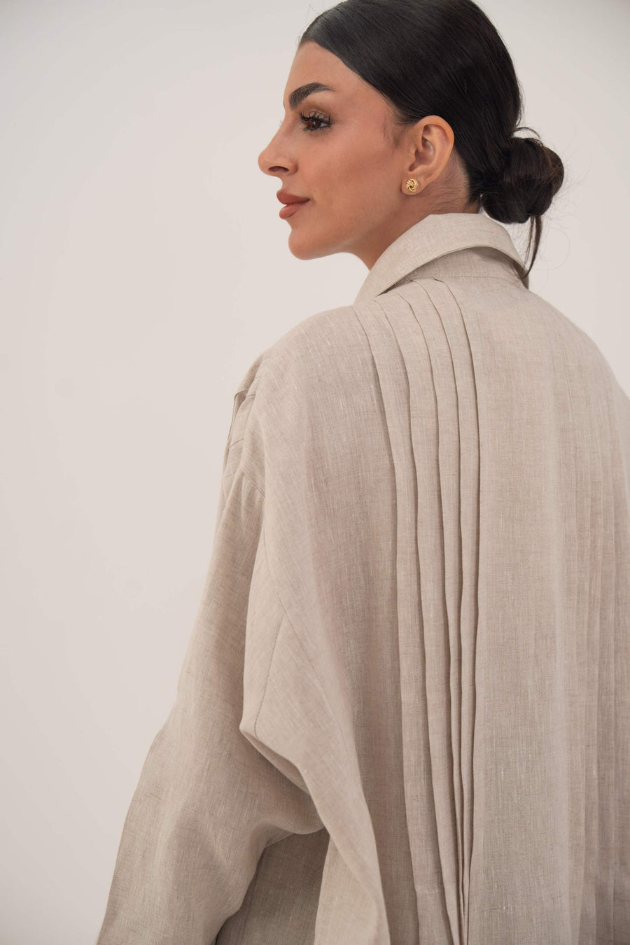 Sandora soft beige linen abaya with classic shirt collar and fabric-covered buttons.