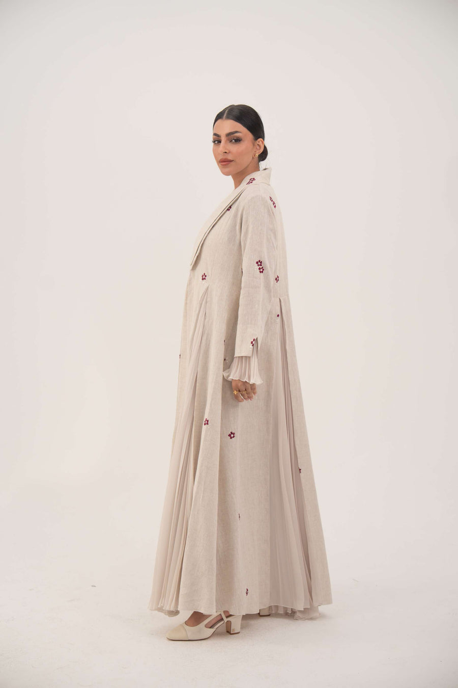 Natural beige linen abaya with burgundy floral embroidery, soft chiffon pleats, and shawl collar.