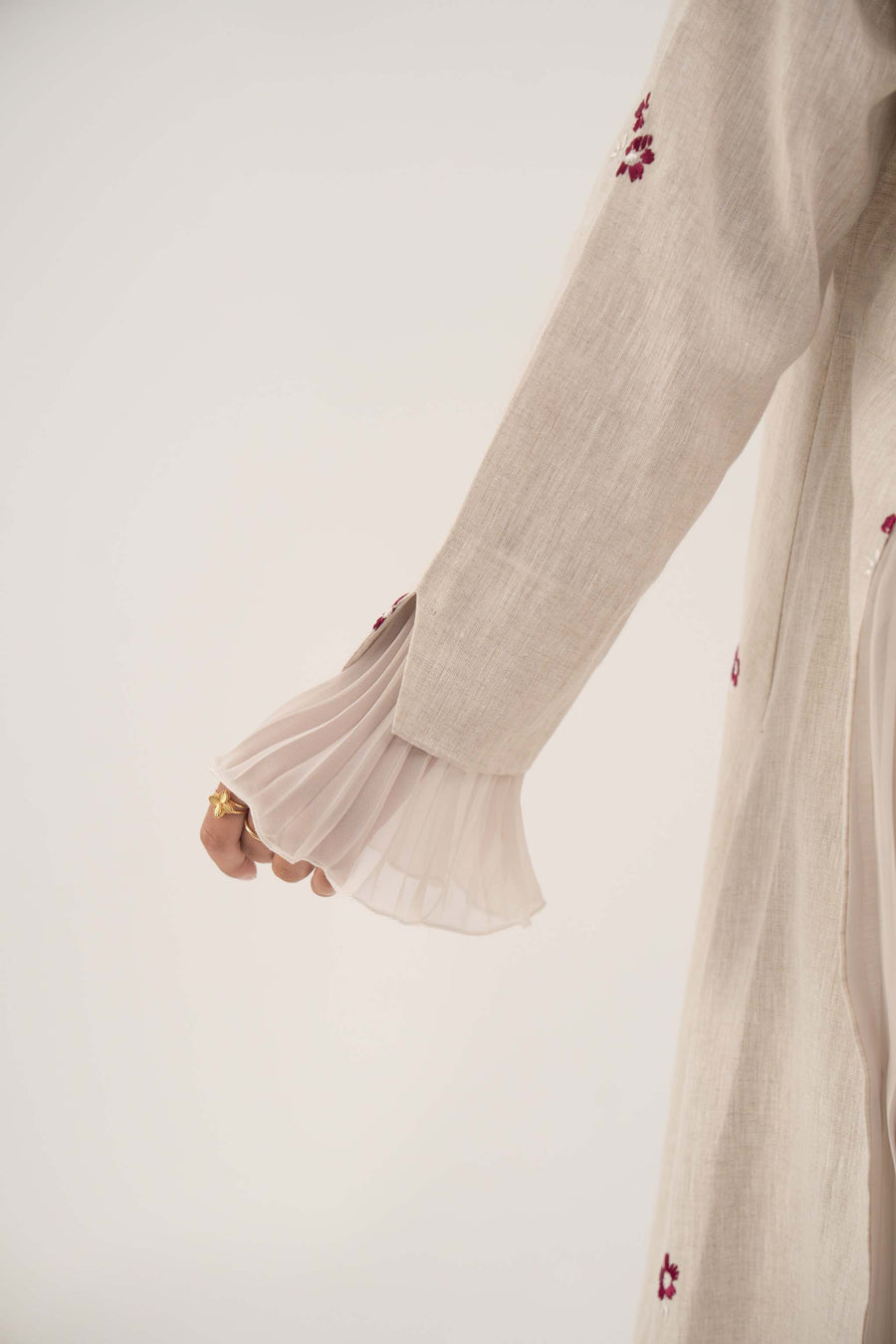 Beige linen abaya sleeve with burgundy floral embroidery and soft chiffon pleats on cuff.