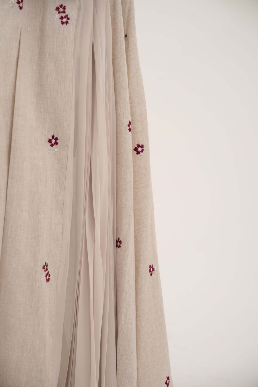 Natural beige linen abaya with burgundy floral embroidery and soft chiffon pleats on sides and sleeves.