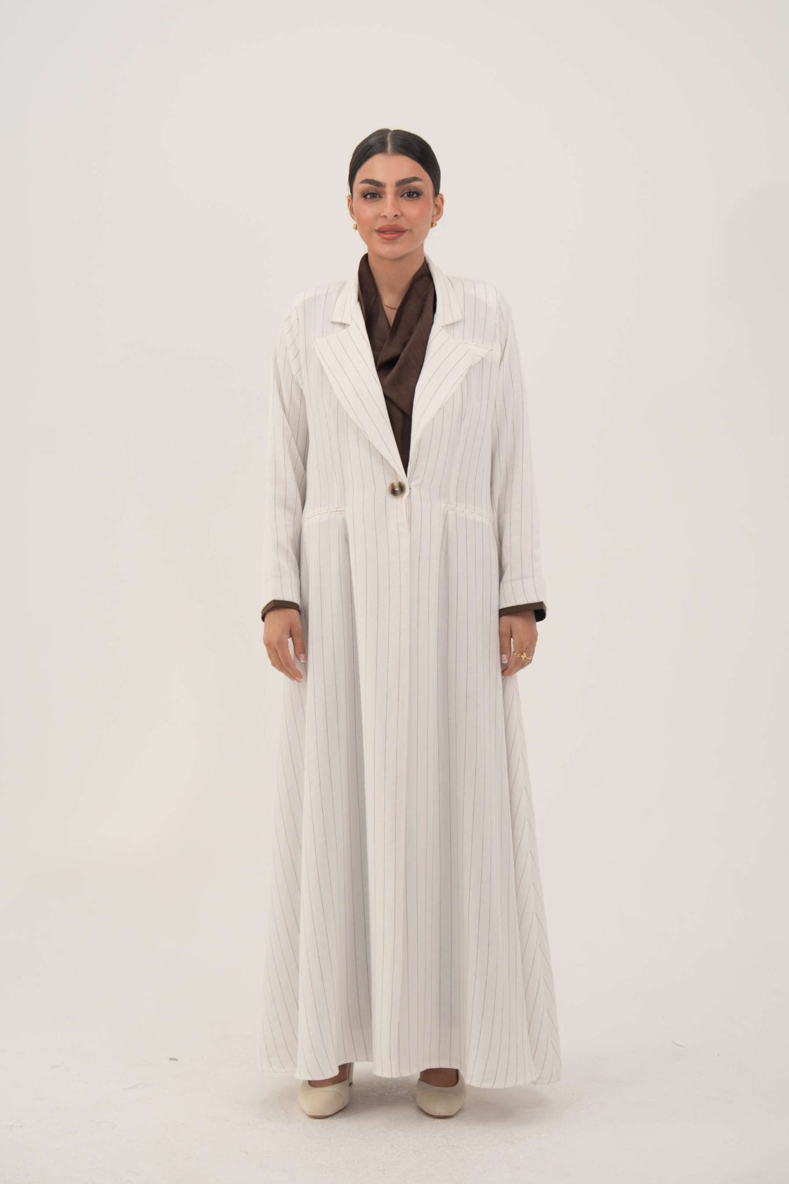 Elegant white linen abaya with soft grey pinstripes, blazer-inspired lapel, single button, and dark brown inner cuffs - Elegant abaya
