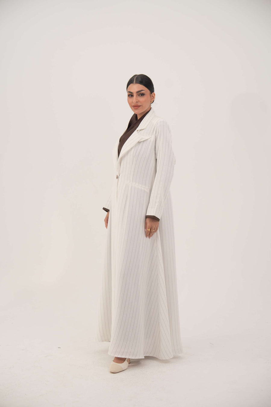 Elegant white linen abaya with grey pinstripes, blazer-inspired cut, single button closure, dark brown inner cuffs, and long flared hem - Elegant abaya