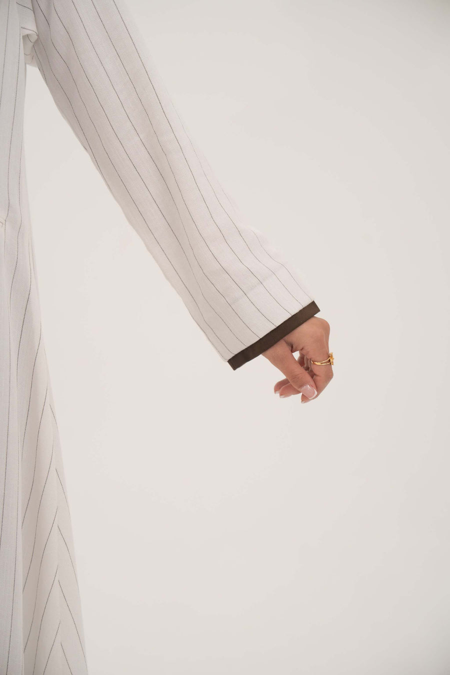close-up of elegant white linen abaya with grey pinstripes and dark brown inner cuff detail on sleeve - Elegant abaya