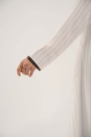 Close-up of a white linen abaya sleeve with grey pinstripes and dark brown inner cuff detailing - Elegant abaya