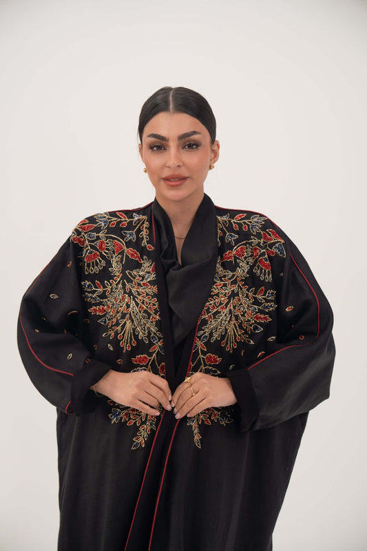 Elegant black linen abaya with multicolored red, gold, and navy shak embroidery and bold red trim