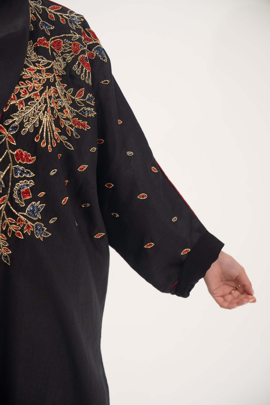 Black linen abaya with red, gold, and navy shak embroidery and red trim on sleeves and shoulders - abaya crafted from premium black linen