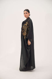 Elegant black bisht abaya with golden bronze shak embroidery and subtle orange seam detailing, made from lightweight breathable linen.