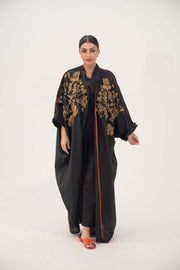 Black Bisht Abaya with gold and bronze embroidery, loose open-front design, rolled cuffs, and subtle orange trim, modeled by woman