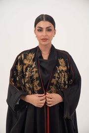 Black linen bisht abaya with golden and bronze shak embroidery and orange trim on model
